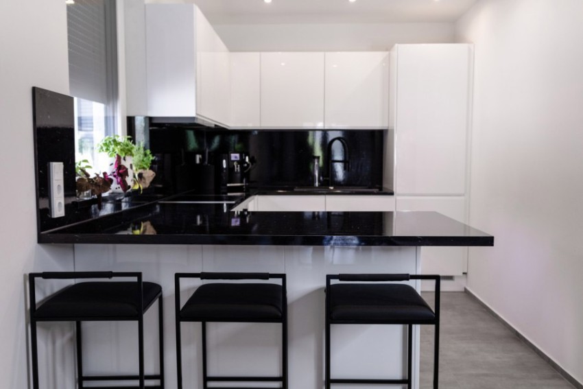 weiße Küche mit schwarzer Arbeitsplatte und Zubehör