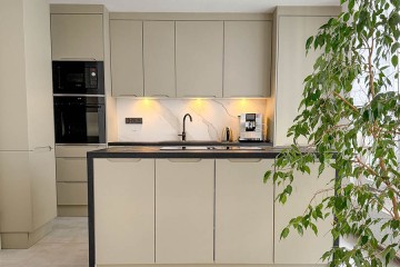 Grifflose Beige Küchenschränke mit Kücheninsel und weiße Panelwand vom Polmöbel mit Küchenplanung - Polmobel Küchen Berlin