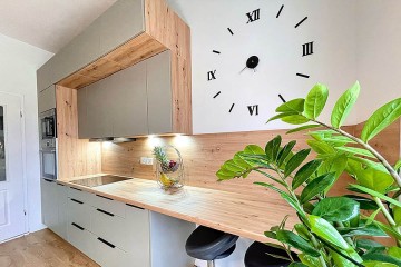 Affordable mid-range kitchen up to €2000 – beige fronts, wood top, black handles. - Polmobel Küchen Berlin