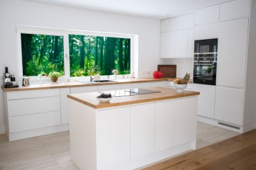 Weiße Küche aus Polen mit Insel und Echtholz-Arbeitsplatte von Polmöbel Berlin. - Polmobel Küchen Berlin